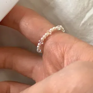 Dettaglio dell'anello fatto a mano con perle bianche e perle di cristallo trasparente