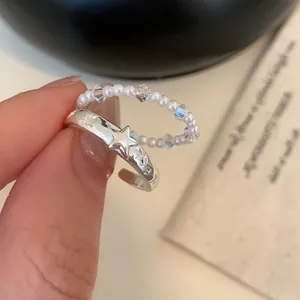 Primo piano dell'anello con stella vintage argento e anello con eleganti perle bianche