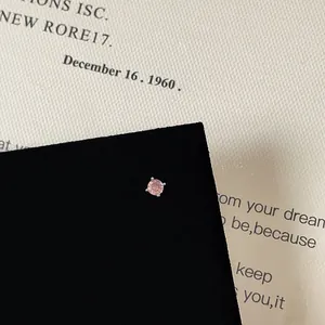 Macro view of pink zircon heart stud earrings with 4-prong silver-tone metal setting