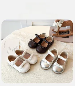 Detailed view of girls' Mary Jane shoes with double bows in coffee and beige colors