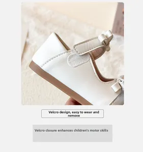 Close-up of girls leather shoe featuring a convenient velcro strap and bow detail