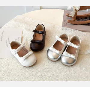 Flat lay of Mary Jane shoes in white brown and silver with double bow details