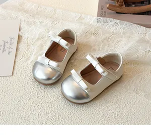 Detailed top view of beige Mary Jane shoes with silver toe caps and double bow accents
