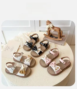 Detail showing girls' summer bow sandals in black, white, and pink with metal buckle