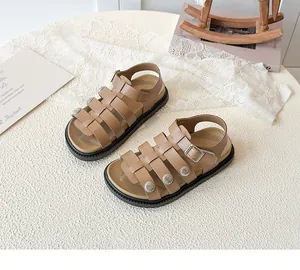 Close-up of retro woven girls' sandals with sun-embossed silver buckles and thick soles