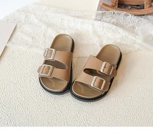 Detail view of the thick non-slip sole and metal buckles on brown kids' sandals