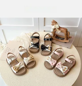Close-up of summer girls' sandals with contrast bows and non-slip wavy rubber soles