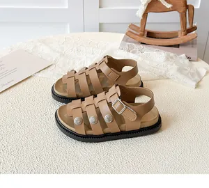 Detail of vintage tan leather kids sandals with carved silver studs and buckle strap
