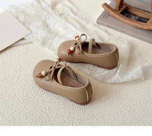 Detail view of brown girls Mary Jane shoes featuring leather bow and colorful bead accents