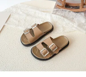 Detail of kids tan leather sandals with silver metal buckles and non-slip rubber soles