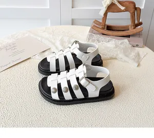 Close-up of girls' white cutout sandals with metallic accents and chunky non-slip soles