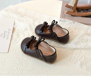 Close-up of girls' dark brown Mary Jane shoes with double bow and velcro closure