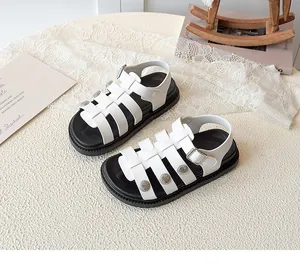 Detail of white roman sandals with braided straps and decorative sun-pattern metal buckles