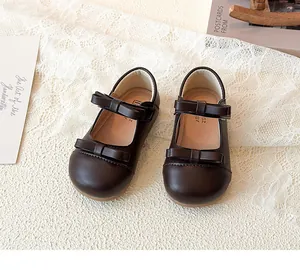 Detail of dark brown girls Mary Jane shoes with double bow and velcro strap