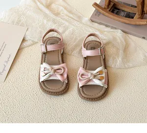 Detail of pink and white girls' sandals with a 3D bow and elegant heart-textured sole