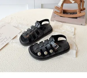 Detail of black gladiator sandals with matte leather straps and silver buckles