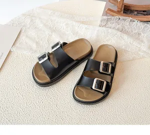 Detail view of children black double-buckle sandals with silver metal accents and cork sole