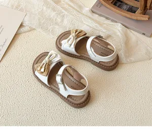 Detail of girls' sandals featuring two-tone bows and durable non-slip rubber soles