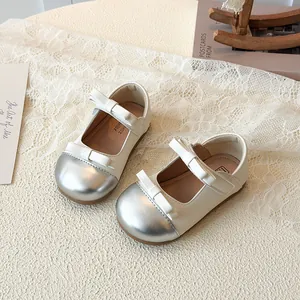 Girls cream Mary Jane shoes with silver toe caps and elegant double bows