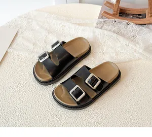 Detail view of children's double strap sandals with silver buckles and thick black sole