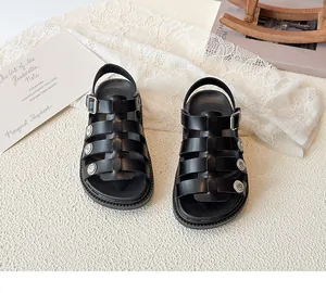 Close-up of black leather Roman sandals with silver floral studs and metal buckles