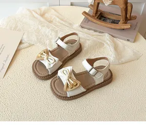 Detailed view of girls' bow sandals with velcro straps and anti-slip rubber soles