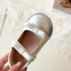 Beige Mary Jane shoes for girls with silver toe cap and cute white bow accents