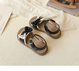 Detailed top view of girl's black and white bow sandals on a vintage aesthetic background