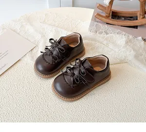 Vue détaillée de chaussures marron pour enfants avec double nœud et bords festonnés