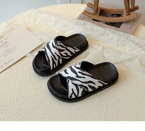 Detail of zebra pattern cross strap sandals with thick black soles and non-slip texture