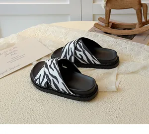 Detail view of children's zebra stripe cross-strap sandals on soft black thick soles