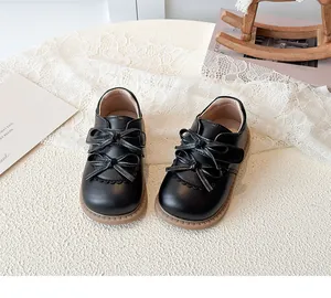 Détail de chaussures Mary Jane noires pour fille avec double nœud et bords festonnés