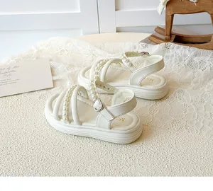 Dettaglio sandali beige da bambina con perle e suola spessa con ammortizzazione