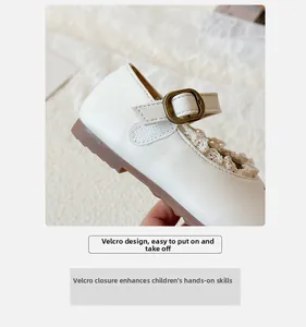 Detail von weißen Mädchen Mary Jane Schuhen mit Spitzenbesatz und Klettverschluss