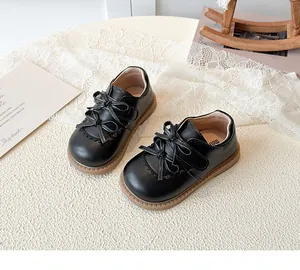 Vue détaillée de chaussures en cuir noir mat pour enfants avec triple nœud