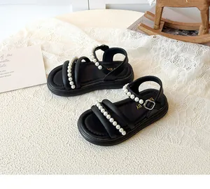 Dettaglio di sandali neri da bambina con file di eleganti perle finte sulla tomaia