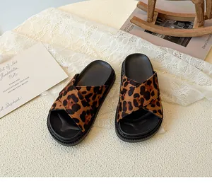 Detailed view of leopard print plush cross strap slide sandals with a thick black sole