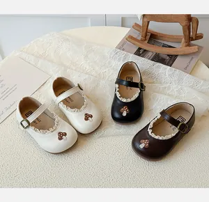 Detailansicht der Kinder Mary Jane Schuhe mit Spitzenkante und Pilzstickerei