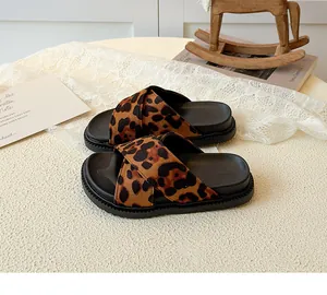 Detail of leopard print crisscross straps and thick non-slip sole on kids' sandals