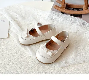 Detailansicht cremefarbener Mädchen Mary Janes mit Schleife und gewelltem Rand Design