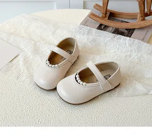 Détail de chaussures Mary Jane crème avec bride en perles et fermeture à scratch