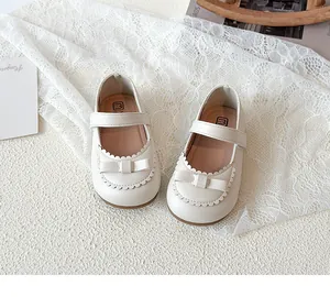 Detailansicht der cremefarbenen Mary Jane Kinderschuhe mit Wellenrand und Schleife