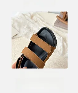 Close-up of brown suede wide toe sandals with thick black soles and stitching details