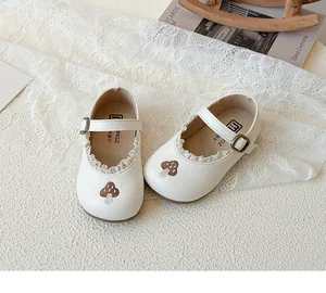 Detail von Baby-Mary-Jane-Schuhen mit Pilzstickerei und feiner Spitze am Rand