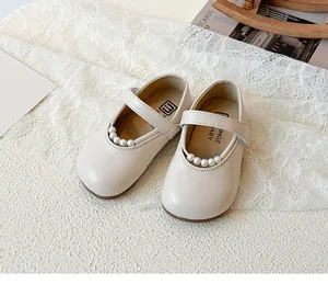 Détail de chaussures Mary Jane pour bébé blanc crème avec perles élégantes et bride