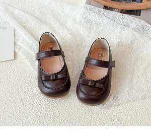 Draufsicht auf dunkelbraune Mary Jane Kleinkindschuhe mit Schleife und Wellenrand