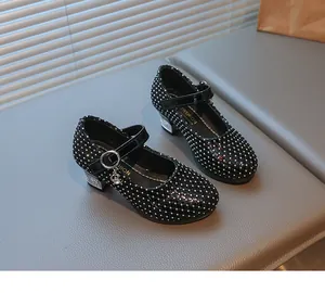 Details von schwarzen Lack-Mary-Janes für Mädchen mit Strasssteinen und Mondanhänger