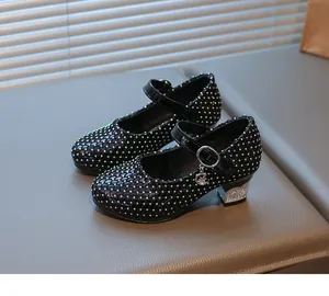 Details von schwarzen Lack-Mary-Janes für Mädchen mit bunten Strasssteinen und Mondanhänger