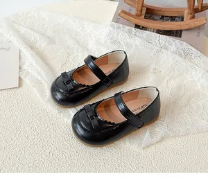 Detailaufnahme schwarzer Mary Jane Kinderschuhe mit Wellenrand und Schleifenverzierung