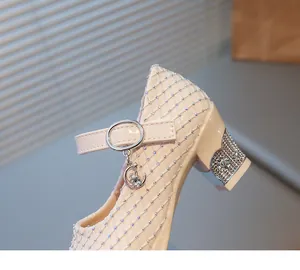 Detailaufnahme des strassbesetzten Absatzes und der Lederstruktur der Mary Jane Schuhe